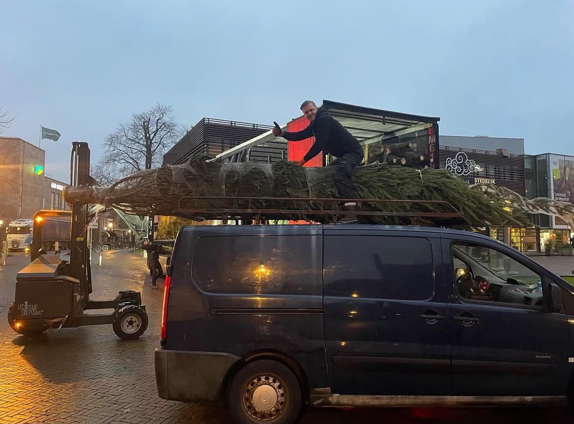 Onze eigen bezorgbus met een kerstboom op het dak in het centrum van Alkmaar